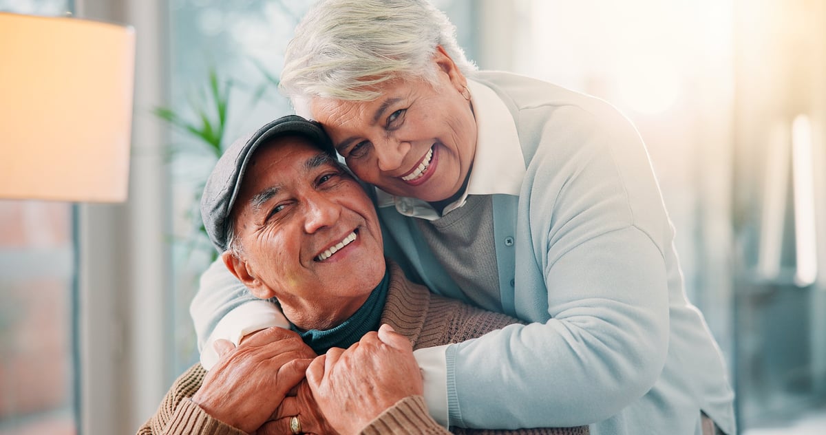 Happy older couple embracing at home, laughing together — representing the joy of staying mentally sharp and connected with loved ones