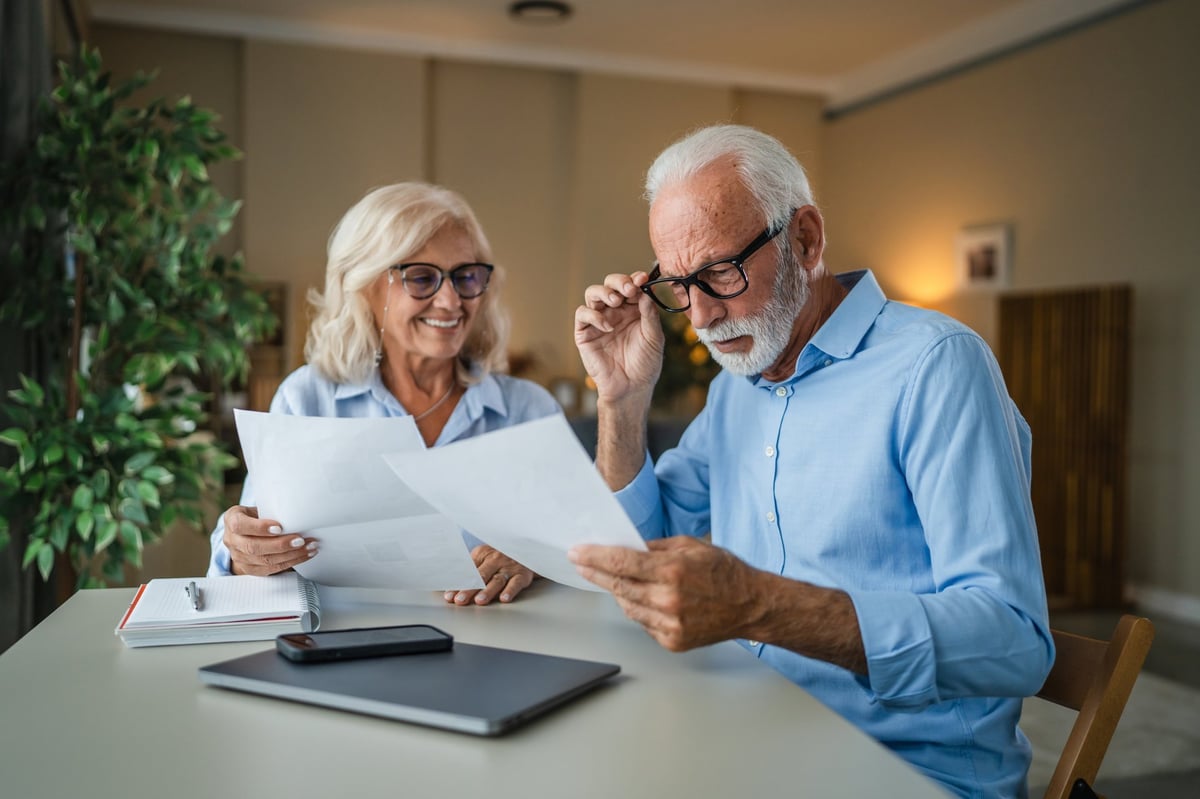 Older couple reviewing paperwork together at home, engaged and focused — representing mental sharpness and active cognitive engagement